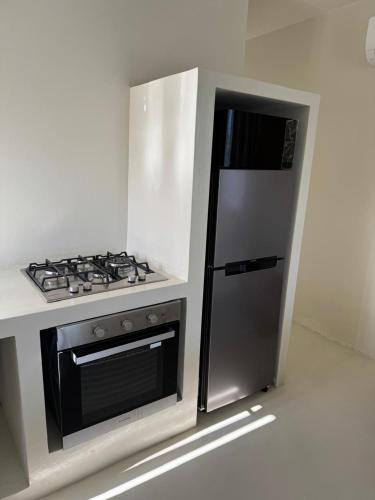 a kitchen with a stove and a refrigerator at Blue Paradise Villa & Apartments in Blue Bay