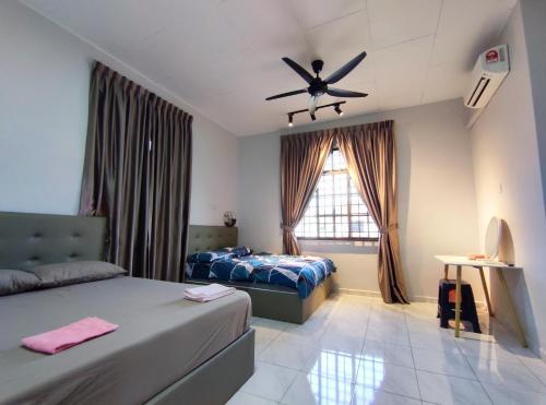 a bedroom with two beds and a ceiling fan at 55 Homestay Bakri Muar Lovely House 12 pax in Kampong Parit Ulu