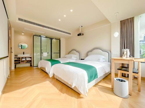a bedroom with two beds and a desk at 西湖柒涧锦月民宿 Lakeside Moon Retreat in Hangzhou
