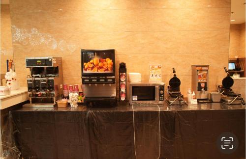 a kitchen with a counter with a microwave and fruit on it at LA Crystal Hotel -Los Angeles-Long Beach Area in Carson