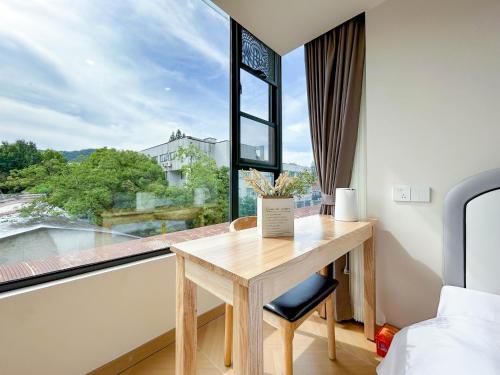 a room with a table and a window with a view at 西湖柒涧锦月民宿 Lakeside Moon Retreat in Hangzhou