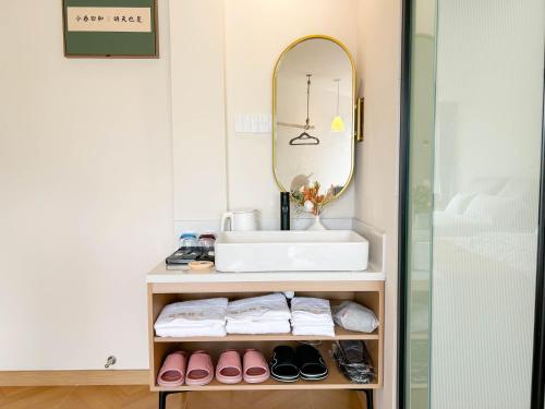 a bathroom with a sink and a mirror at 西湖柒涧锦月民宿 Lakeside Moon Retreat in Hangzhou