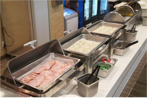 a row of trays of food on a counter at LA Crystal Hotel -Los Angeles-Long Beach Area in Carson