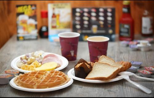 three plates of breakfast food on a table with drinks at LA Crystal Hotel -Los Angeles-Long Beach Area in Carson