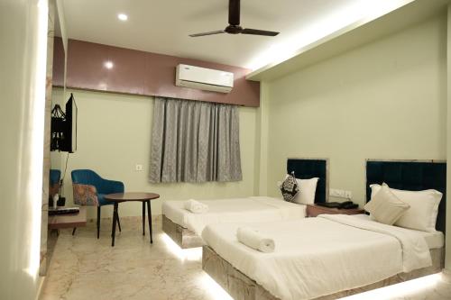 a hotel room with two beds and a table at The Infigo in Beherāpāt