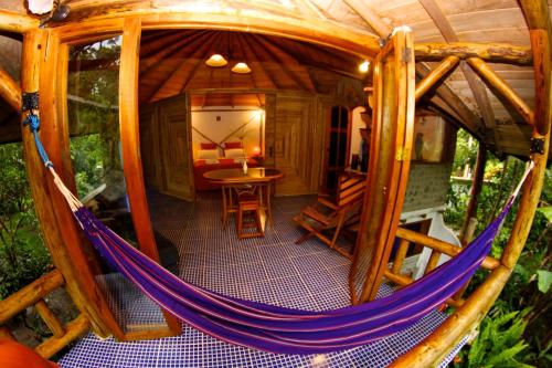 a hammock in a tree house with a table at Saguamby Mindo Lodge in Mindo