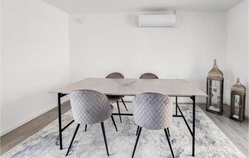 a dining room table with three chairs and a table at Nice Home In Helsingborg in Helsingborg