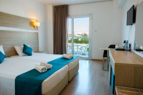 a hotel room with a bed with towels on it at Kapetanios Bay Hotel Protaras in Protaras