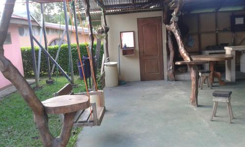 a porch with a swing and a table and a chair at Cabinas Vista Miravalles in Bijagua