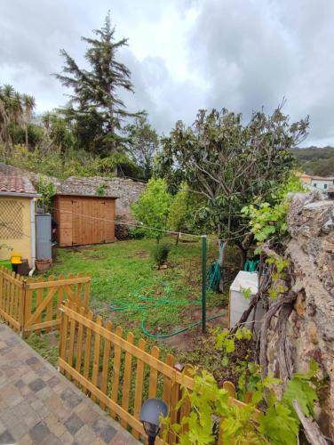 a garden with a fence and a yard at Monolocale con veranda e giardino a Rio Marina in Rio Marina