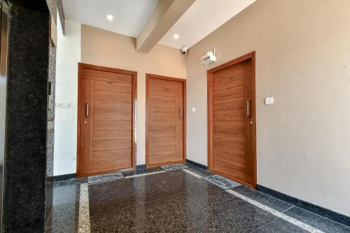 two wooden doors in a room with a tile floor at Ega Orchid, Luxury Apartment in Brookefield in Bengaluru