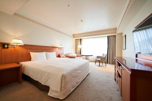 a hotel room with a large bed and a table at THE GLOBAL VIEW Nagasaki in Nagasaki