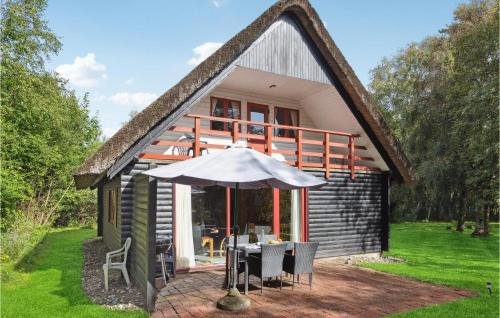 een klein huis met een tafel en een paraplu bij Holiday Home Kliren Rømø Ix in Rømø Kirkeby