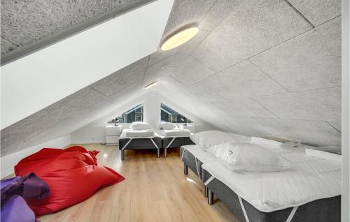 a attic bedroom with two beds and two tables at Nice Home In Bogense With Wifi in Bogense