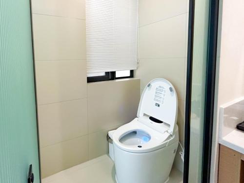 a small bathroom with a toilet with the lid up at 西湖柒涧锦月民宿 Lakeside Moon Retreat in Hangzhou