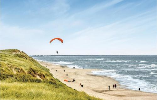 a group of people on a beach flying a kite at Nice Home In Hvide Sande With Sauna in Bjerregård