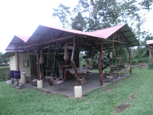 a pavilion with a table and chairs under it at Cabinas Vista Miravalles in Bijagua