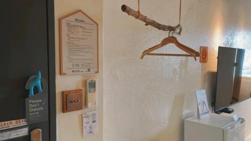 a wall with a sign and a hanger on it at Chill Roof Hotel in Taipei