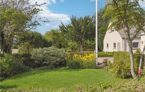 a garden with a white house and trees and flowers at Lovely Home In Bogense With Kitchen in Bogense