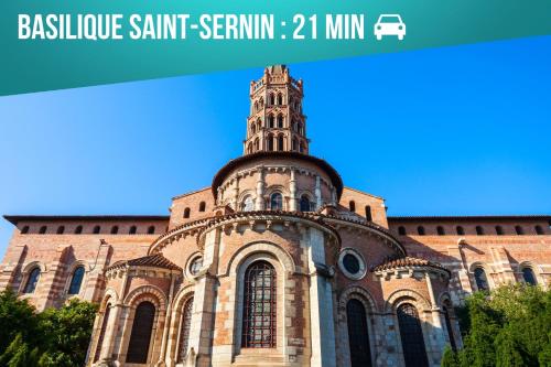 a building with a clock tower on top of it at Le Cocon de Lespinasse - Parking - Checkin Autonome in Lespinasse