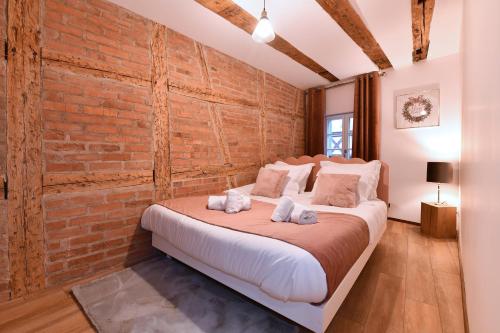 une chambre avec un mur de briques et un lit dans l'établissement La vie en rose 6GUESTS-3BR, à Colmar