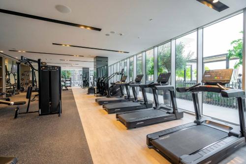 a row of treadmills in a gym with windows at GuestReady - Elegant 1BR l Premium Amenities in Dubai