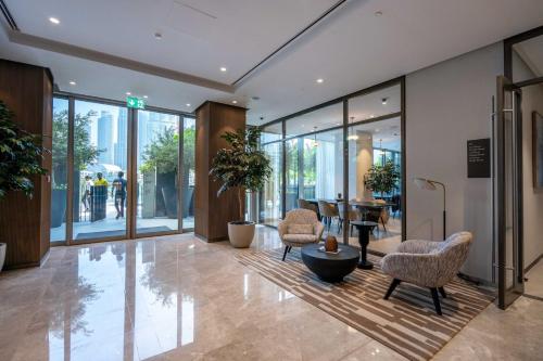 a lobby with chairs and a table in a building at GuestReady - Elegant 1BR l Premium Amenities in Dubai