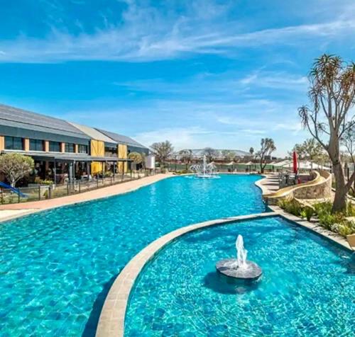 - une piscine d'eau bleue dans un complexe dans l'établissement Modern Retreat in Pretoria with Lagoon Pool & Gym, à Pretoria