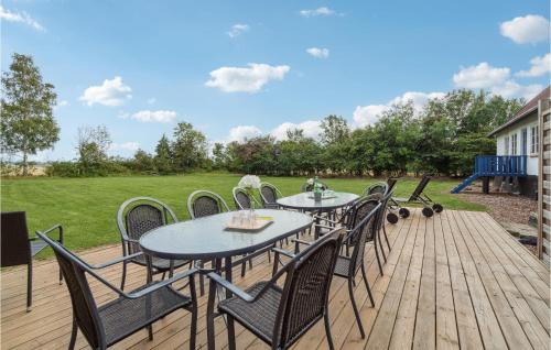 a wooden deck with tables and chairs on it at Markeregaard in Spidsegård