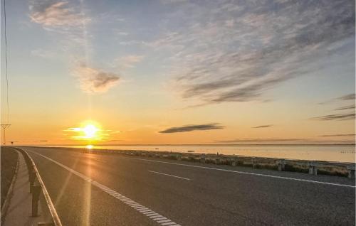 a road with the sunset in the background at Holiday Home Vestergade Rømø Iii in Rømø Kirkeby