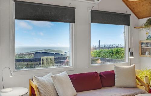 a living room with a couch and two windows at Nice Home In Esbjerg V in Esbjerg