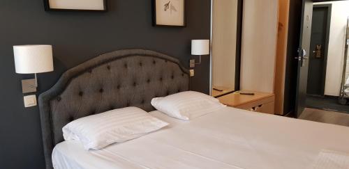 a bedroom with a bed with two pillows on it at Hotel Aviation in Brussels