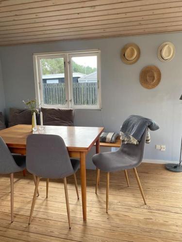 a dining room with a wooden table and chairs at Cosy Holiday Home - 300 m to beautiful beach and cafés in Karrebæksminde