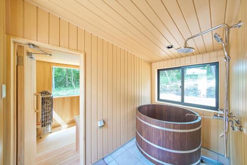 a large wooden tub in a bathroom with a window at Azumino Komorebi - 安曇野こもれび - in Azumino