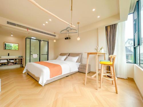 a bedroom with a bed and a desk and a chair at 西湖柒涧锦月民宿 Lakeside Moon Retreat in Hangzhou