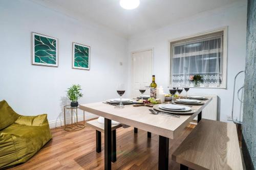 a dining room with a table with glasses of wine at Comfortable 3 Bedroom Terraced Home, Sleeps 5, Monthly Extended Stays in Northampton