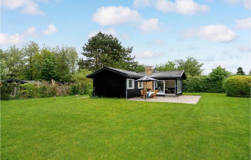a small black cabin in the middle of a yard at Pet Friendly Home In Hornbæk With Wifi in Hornbæk