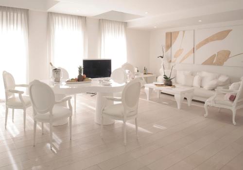 a white dining room with a white table and chairs at Boscolo Nice Hotel & Spa in Nice