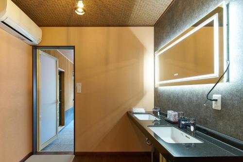 a bathroom with two sinks and a mirror at Azumino Komorebi - 安曇野こもれび - in Azumino