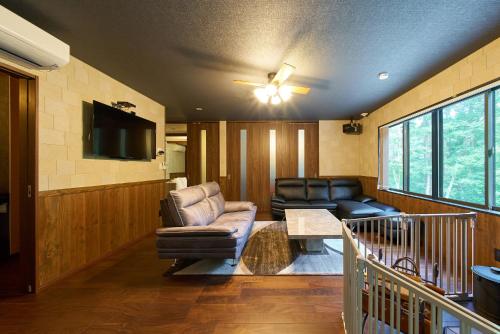 a living room with a couch and a tv at Azumino Komorebi - 安曇野こもれび - in Azumino