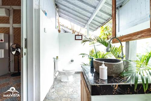 a bathroom with a sink and plants on a counter at D'Pendem Cottage's by Bukit Vista in Uluwatu