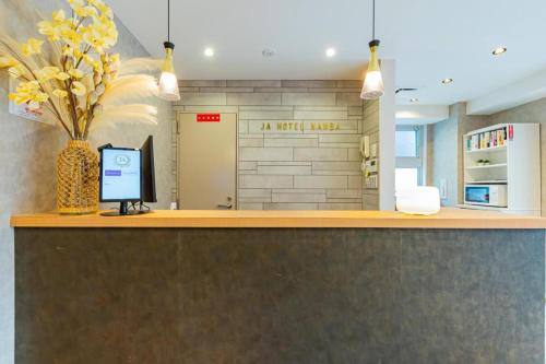 a reception counter with a vase of flowers on it at JA Hotel Namba in Osaka