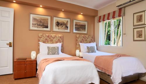 a bedroom with two beds and a window at Rosedene Guest House in Cape Town