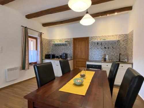 a kitchen with a wooden table and black chairs at Pilis lelke vendégház in Esztergom