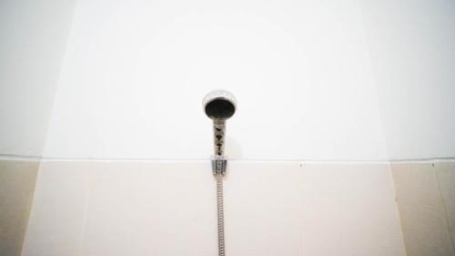 MedokanayuにあるCozy Living Studio at Bale Hinggil Apartment By Travelioの白い壁のバスルーム(照明付)