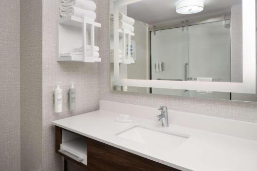 a bathroom with a white sink and a mirror at Hampton Inn Roanoke/Hollins - I-81 in Roanoke