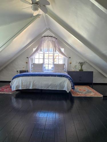 a bedroom with a bed in a attic with a window at Majestic Secret in Cape Town