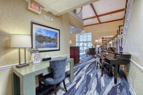 an office with a desk and a piano in a room at Comfort Suites Appleton Airport in Appleton