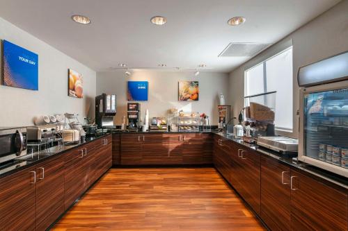 a large kitchen with wooden cabinets and a counter top at Comfort Inn St Louis Airport in Bridgeton