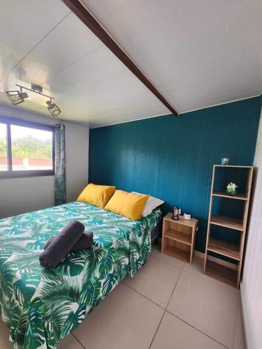 Un dormitorio con una cama y una pared azul. en Te Ika Nui Lodge, en Faaone